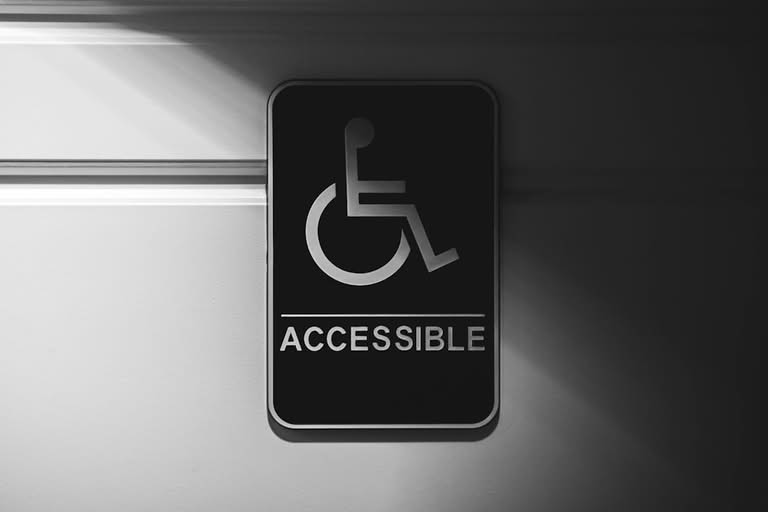 A black and white sign with a wheelchair symbol and the word "ACCESSIBLE" indicates accessibility for people with disabilities.